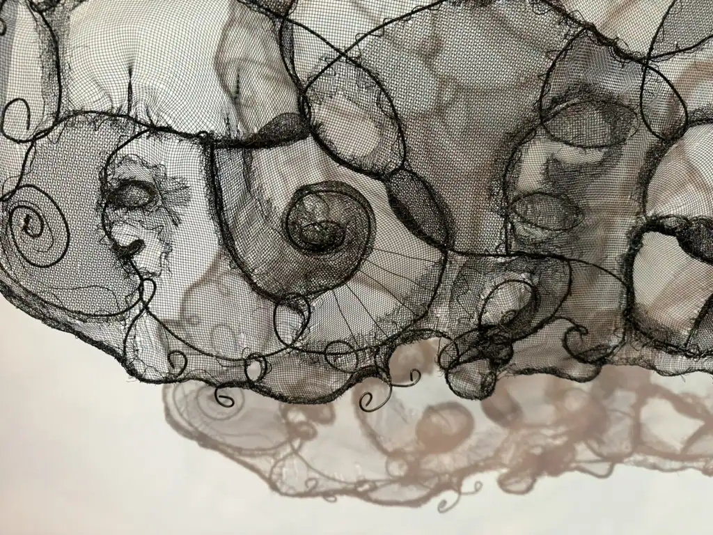 Detail of abstract screen and wire art with swirling black lines and intricate patterns.