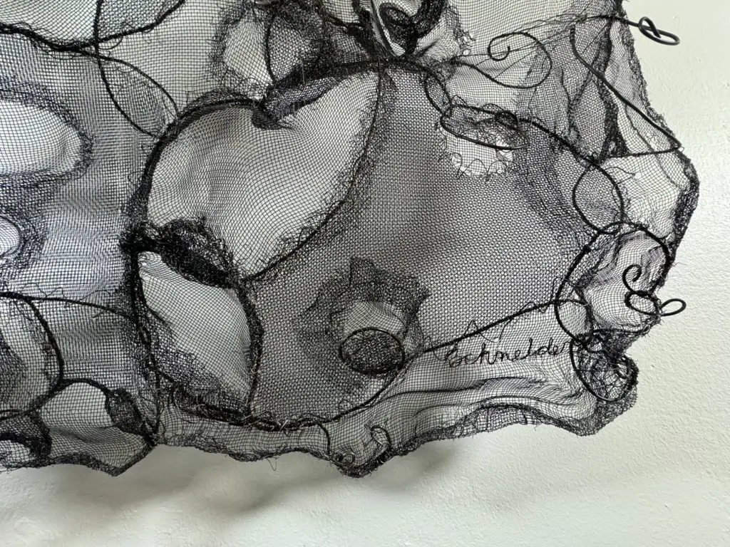 Detail of abstract screen and wire art with swirling black lines and intricate patterns.
