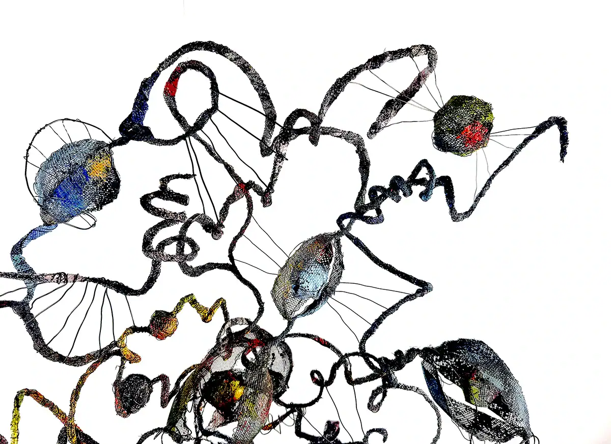 Abstract wire sculpture with colorful elements.