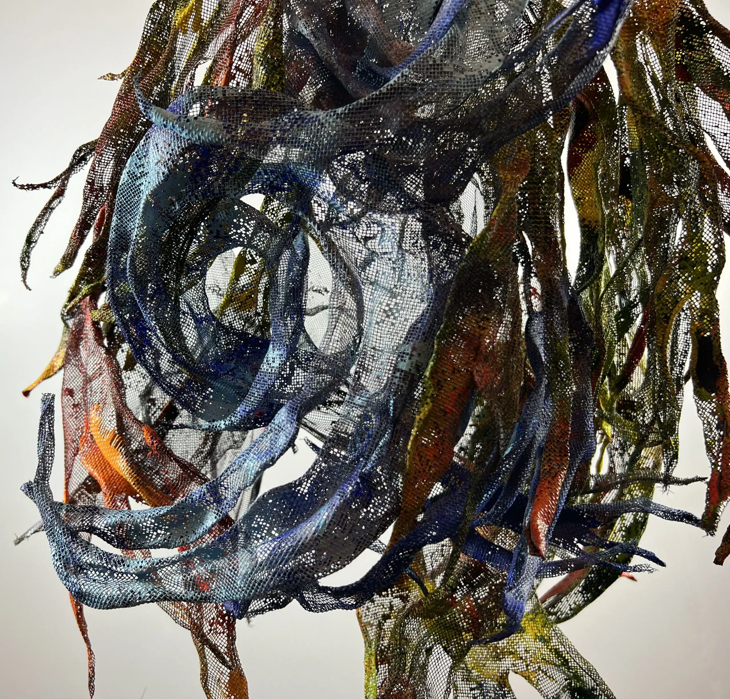 Colorful mixed-media abstract sculpture with flowing, ribbon-like elements.